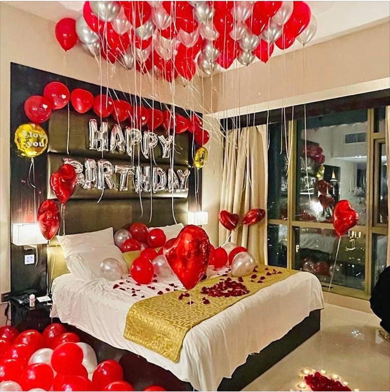 Basic room decoration with red and silver balloons around a birthday bed setup